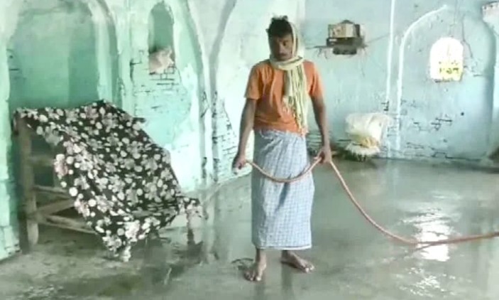 A villager cleans the mosque premises