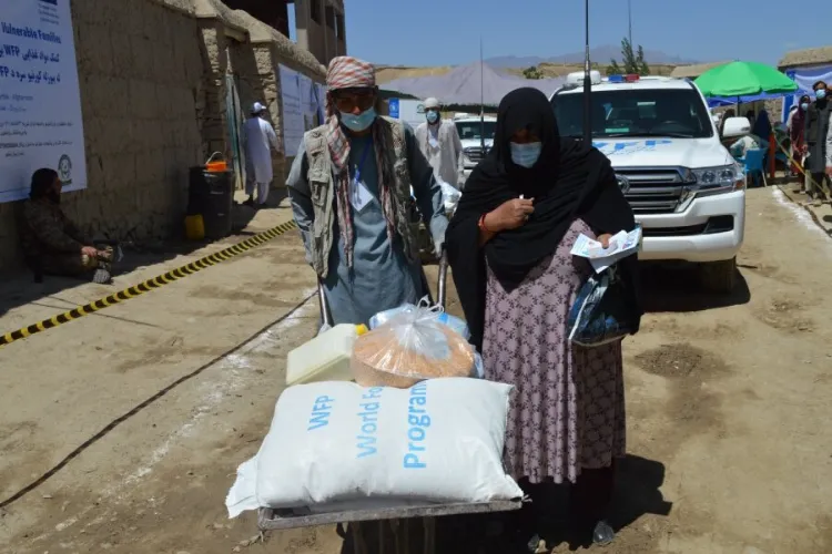 An Afghan woman takes home a bag of flour given by the UN Food programme