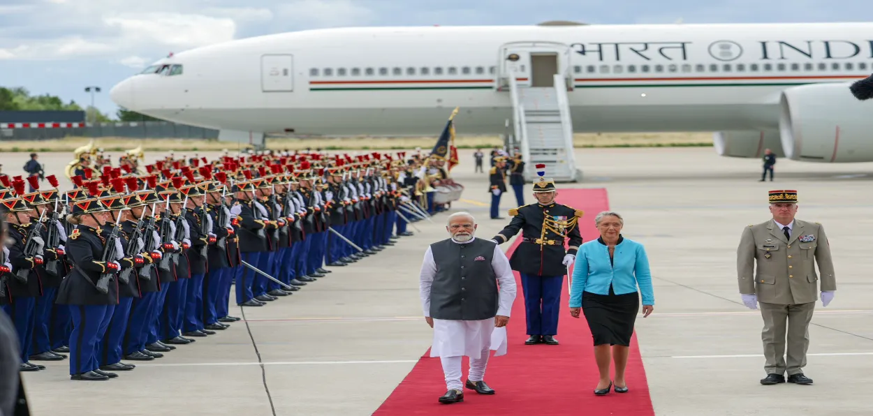 Prime Minister Narendra Modi receives a ceremonial welcome on his arrival, at the airport, in Paris on Thursday. French PM Elisabeth Borne is also seen