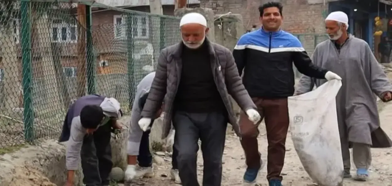 Farooq Ahmed Ganai cleaning the streets of his village, Sadiwara, South Kashmir