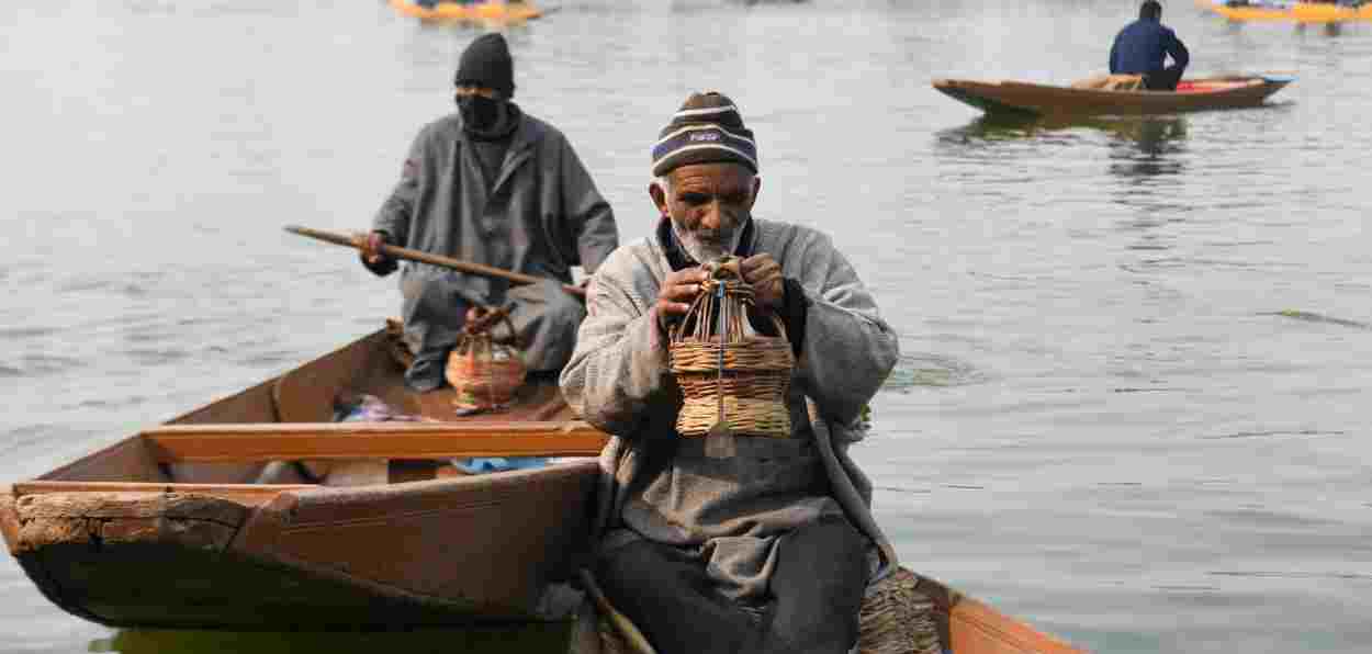 A Kashmiri boatman with kangri to beat freezing weather in the Dal Lake (Pics: Basit Zargar)