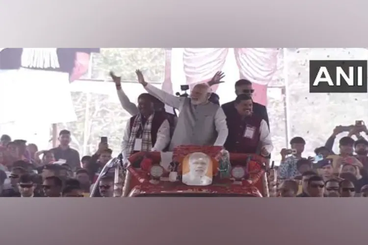 Prime Minister Narendra Modi waving at the public during a road show in Jhabua