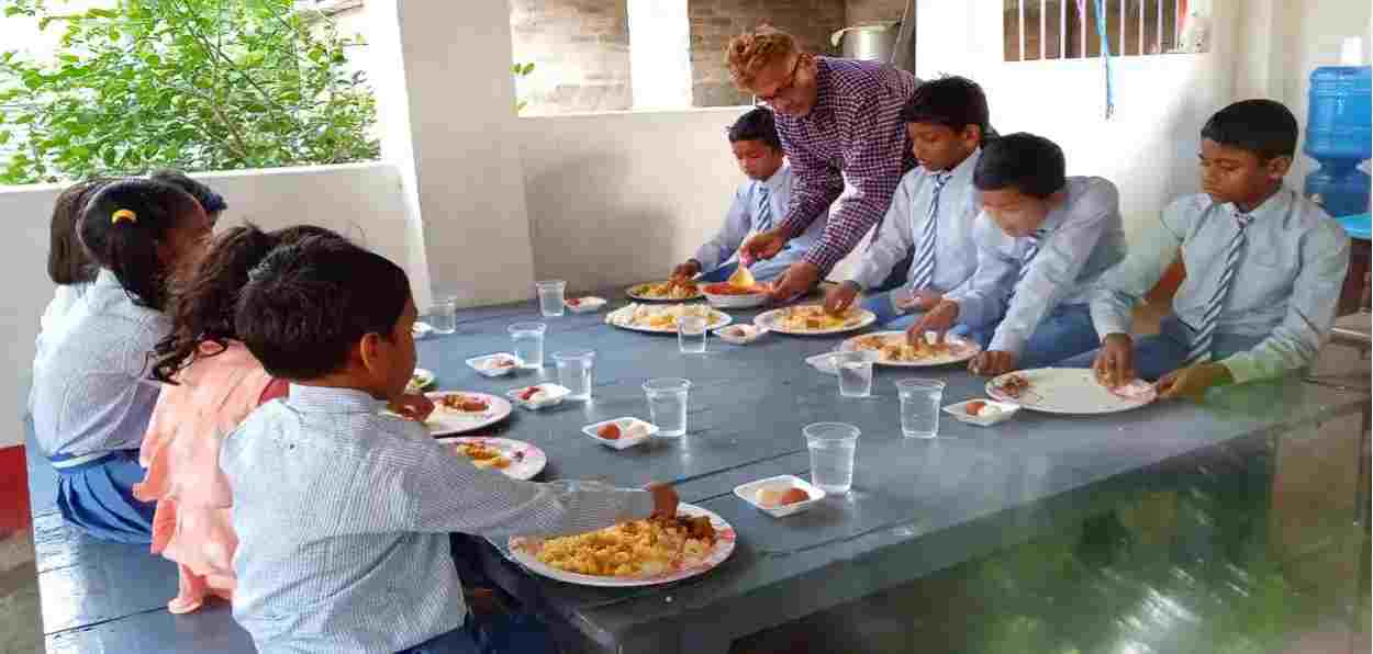 Nazrul Islam Nazmi serving food to students