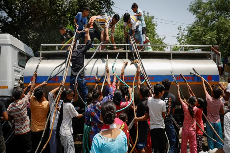 Residents fill their containers with drinking water from a municipal tanker on a hot summer day in New Delhi.