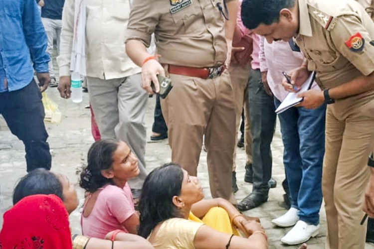 UP Policeman speaking with kin of the victims of Hathras stampede