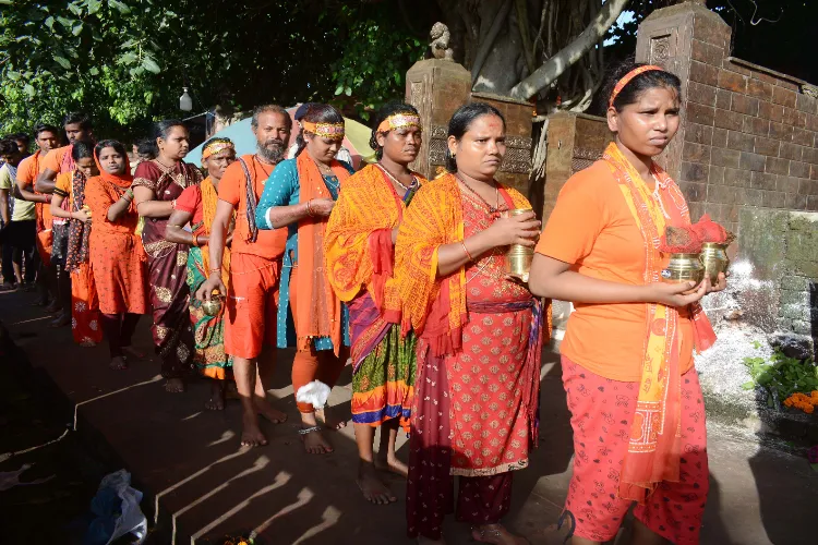 Devotees carrying Ganga water stand in queues to offer Jalabhishek to Lord Shiva