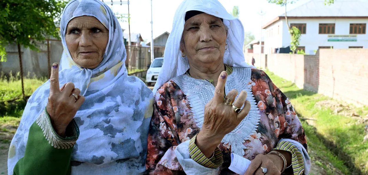 Kashmiri women showing their finger mark after casting their vote in the Lok Sabha elections