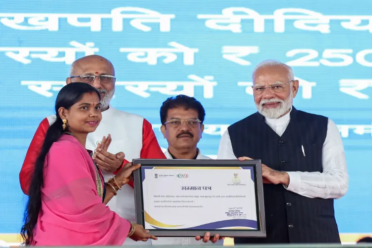 PM Modi hands over certificate during the Lakhpati Didi Sammelan in Jalgaon