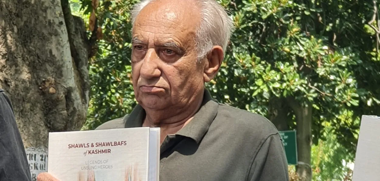 Dr Abdul Ahad with his book on Shawl makers of Kashmir