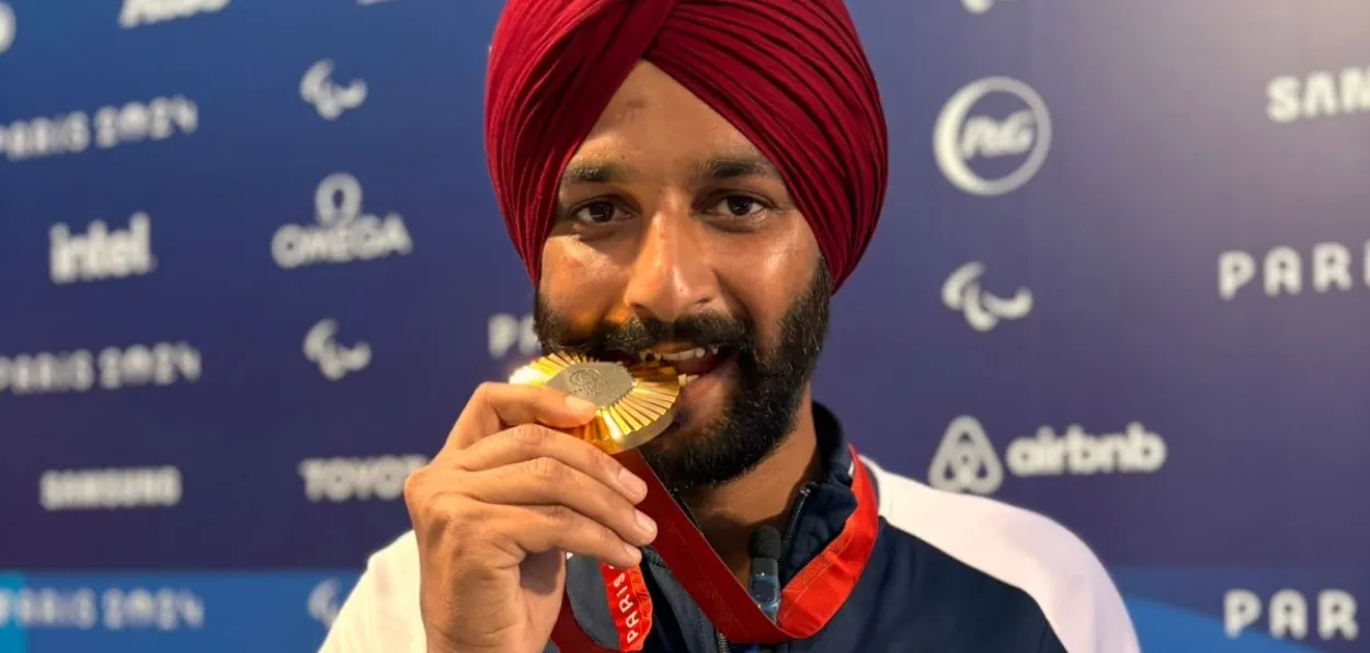 Archer Harvinder Singh biting his gold medal at Paris Paralympics