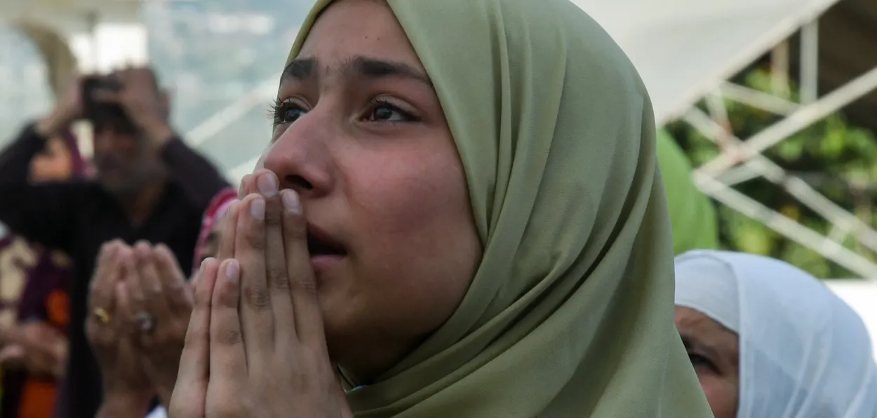 A Kashmiri woman in devotion at the deedar (viewing) of the Holy Relic of Prophet Muhammad at Hazratbal shrine in Srinagar, Kashmir