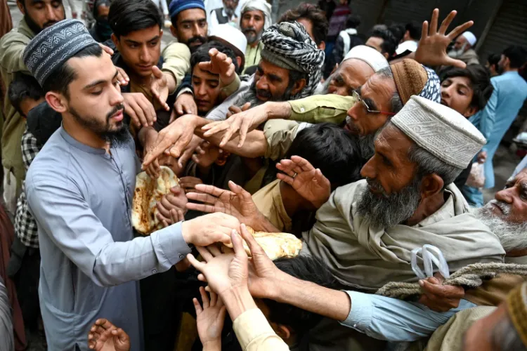 People collecting free bread from a distribution point in Peshhawar (Credit: Abdul Majeed/AFP via Getty Images)