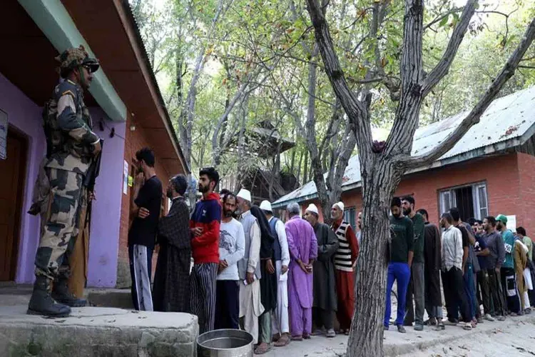 People standing in a long queue to  cast their votes