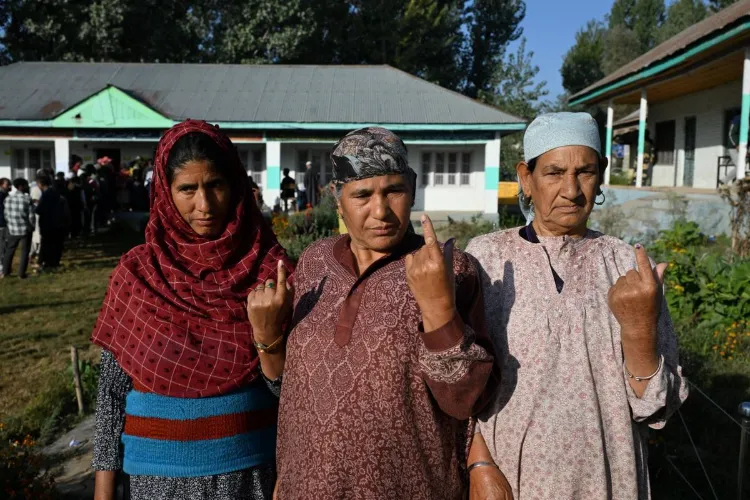 Women voters proudly display inked fingers after casting their votes in the final phase of Jammu and Kashmir elections