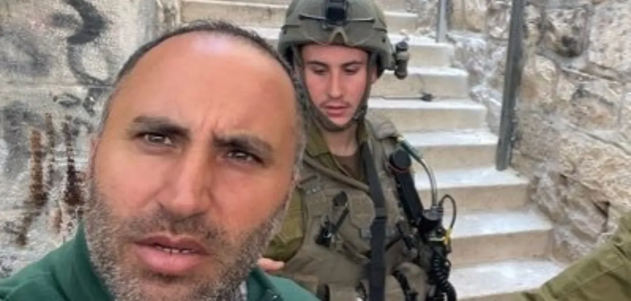 Amro Issa, Palestinian peace activist and winner of Right Livelihood prize standing close to an Israeli soldier