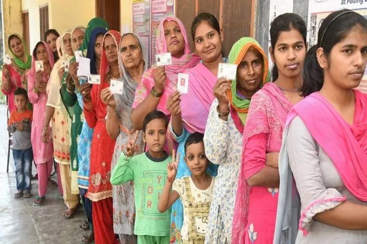 Women stand in a queue to cast their votes at a polling station 