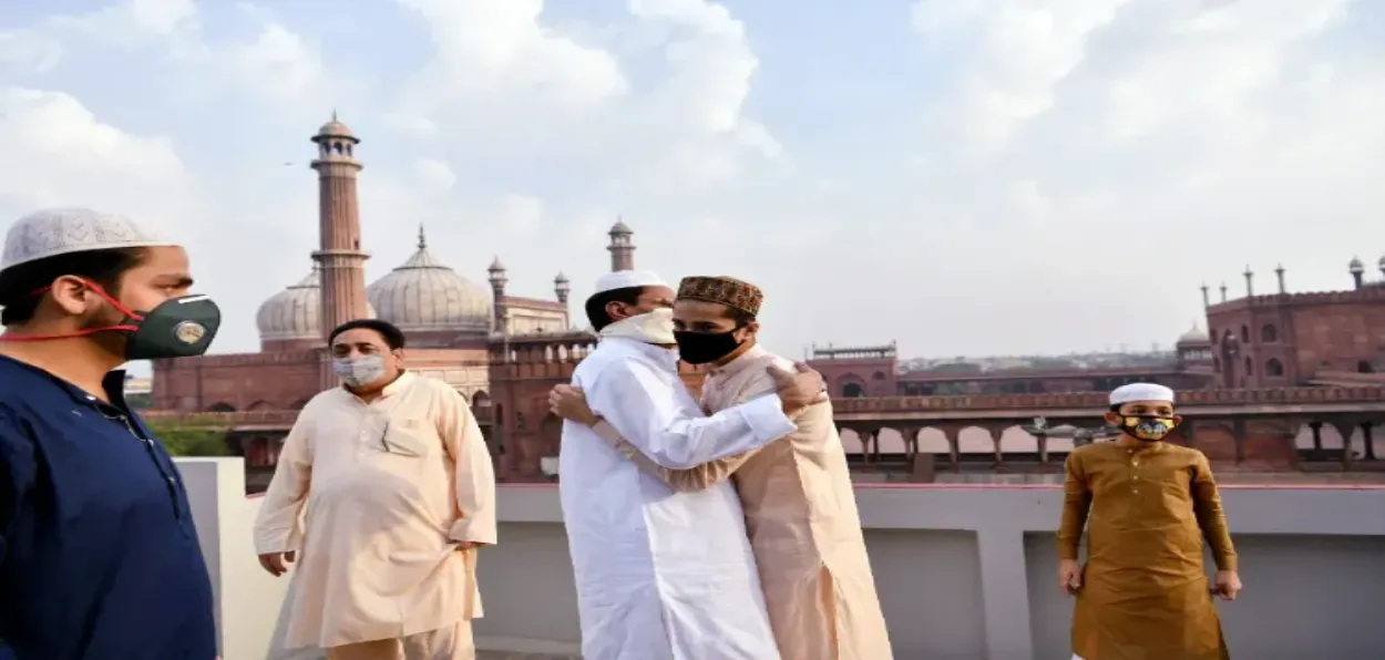 Muslims hugging each other in the backdrop of Jama Masjid in Delhi