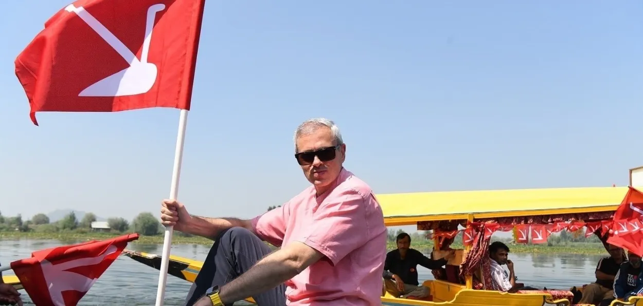 Omar Abdullah holding the flag of National Conference while campaigning in the Dal lake of Srinagar