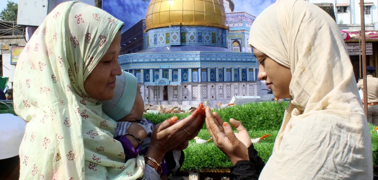 Muslim women pray while attending Eid-ae-Milad ul-nabi procession, in Ahmedabad