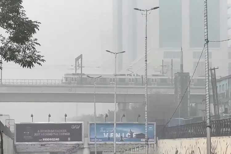 A metro train passing through smog enveloped Delhi track