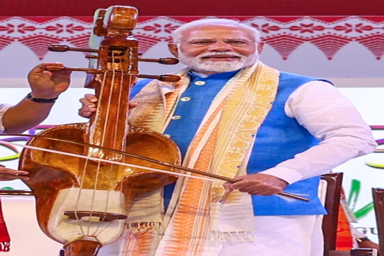 PM Modi tries his hands on Sarinda - a stringed musical instrument used by the Bodo community of Assam