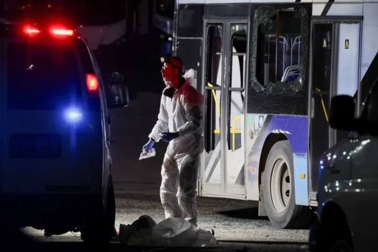 An Israeli member of the bomb disposal; squad inspecting stationary buses after the blasts