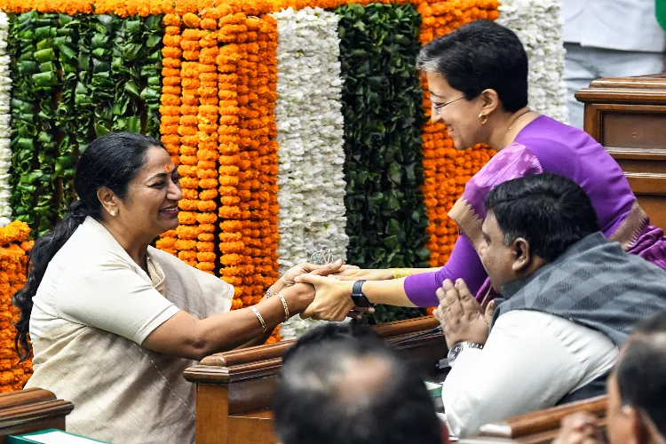 Delhi Chief Minister Rekha Gupta exchanges greetings with LoP Delhi Assembly Atishi after taking oath as a Member of the Legislative Assembly of Delhi during the first session of the Delhi Assembly in New Delhi on February 24