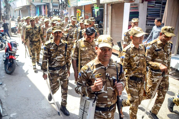 Police personnel conduct a flag march to ensure security ahead of the Holi festival in Sambhal, Uttar Pradesh on March 13, 2025