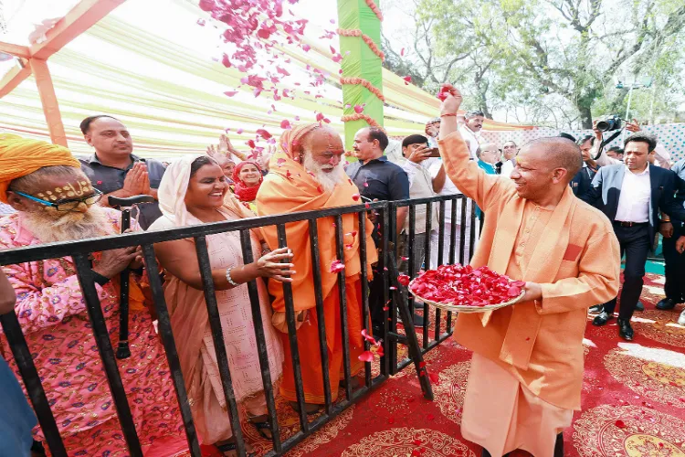 UP CM Yogi Adityanath showers flowers on devotees on the occasion of 'Phoolon vali Holi' during the inauguration of Braj Rangotsav 2025 at Barsana in Mathura on March 14