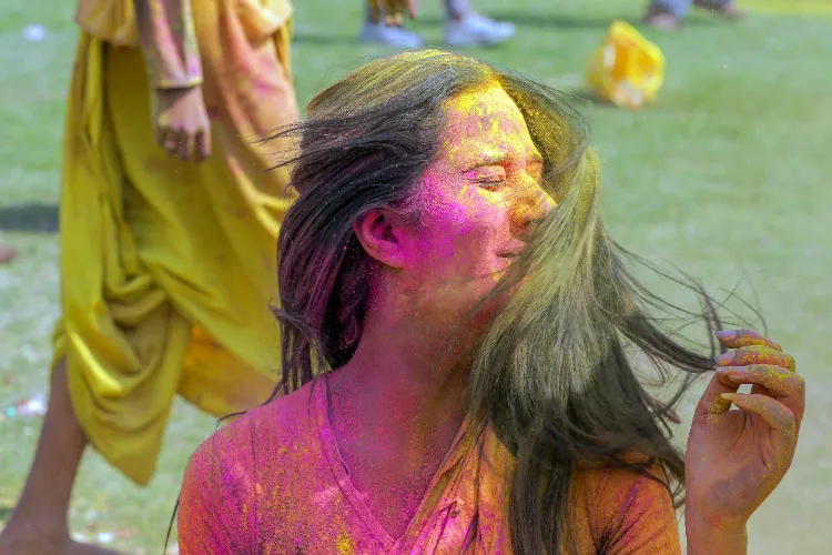  A girl plays with her tresses drenched in colours during Holi celebrations, at the ISCKON temple in Amritsar on Thursday.