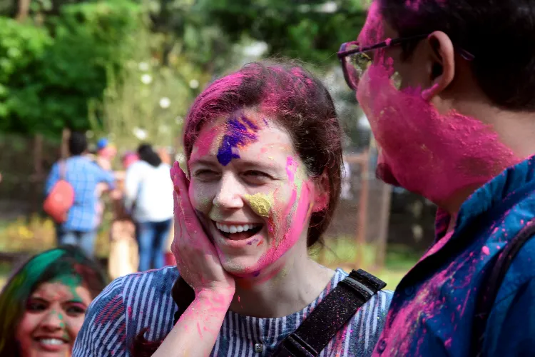 Foreigners playing with colours on the occasion of the Holi festival, in Kolkata on Friday