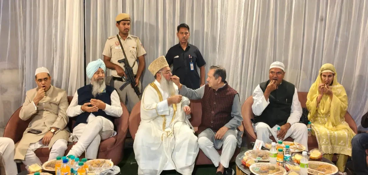 Imam Umair Ilyasi feeding dates to Indresh Kumar at the all-faith Iftar party in Delhi