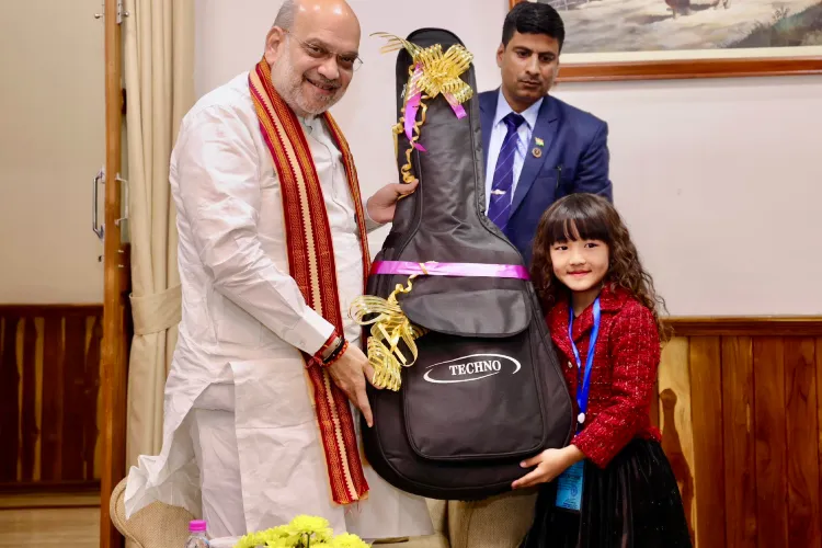 Union Home Minister Amit Shah gifting guitar to Esther Lalduhawmi Hnamte at Aizwal