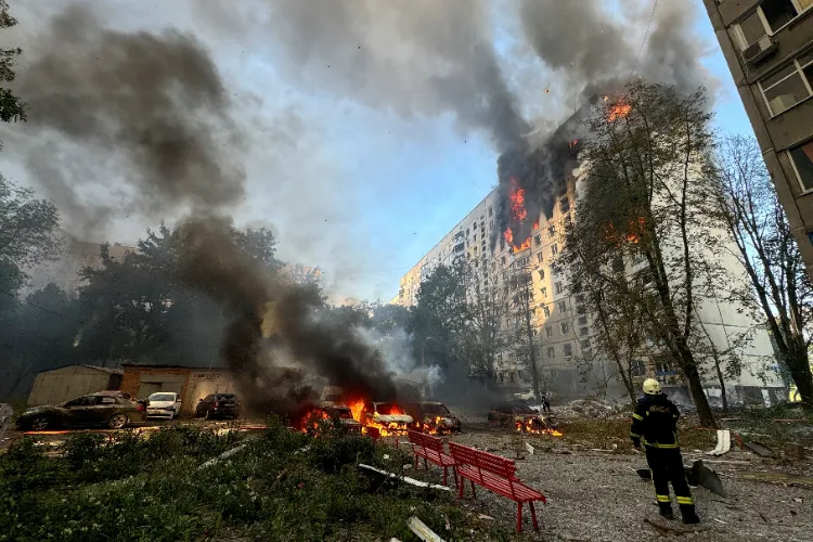 A firefighter looks at an apartment building and cars which burn after a Russian air strike, amid Russia's attack on Ukraine in Kharkiv (File photo)